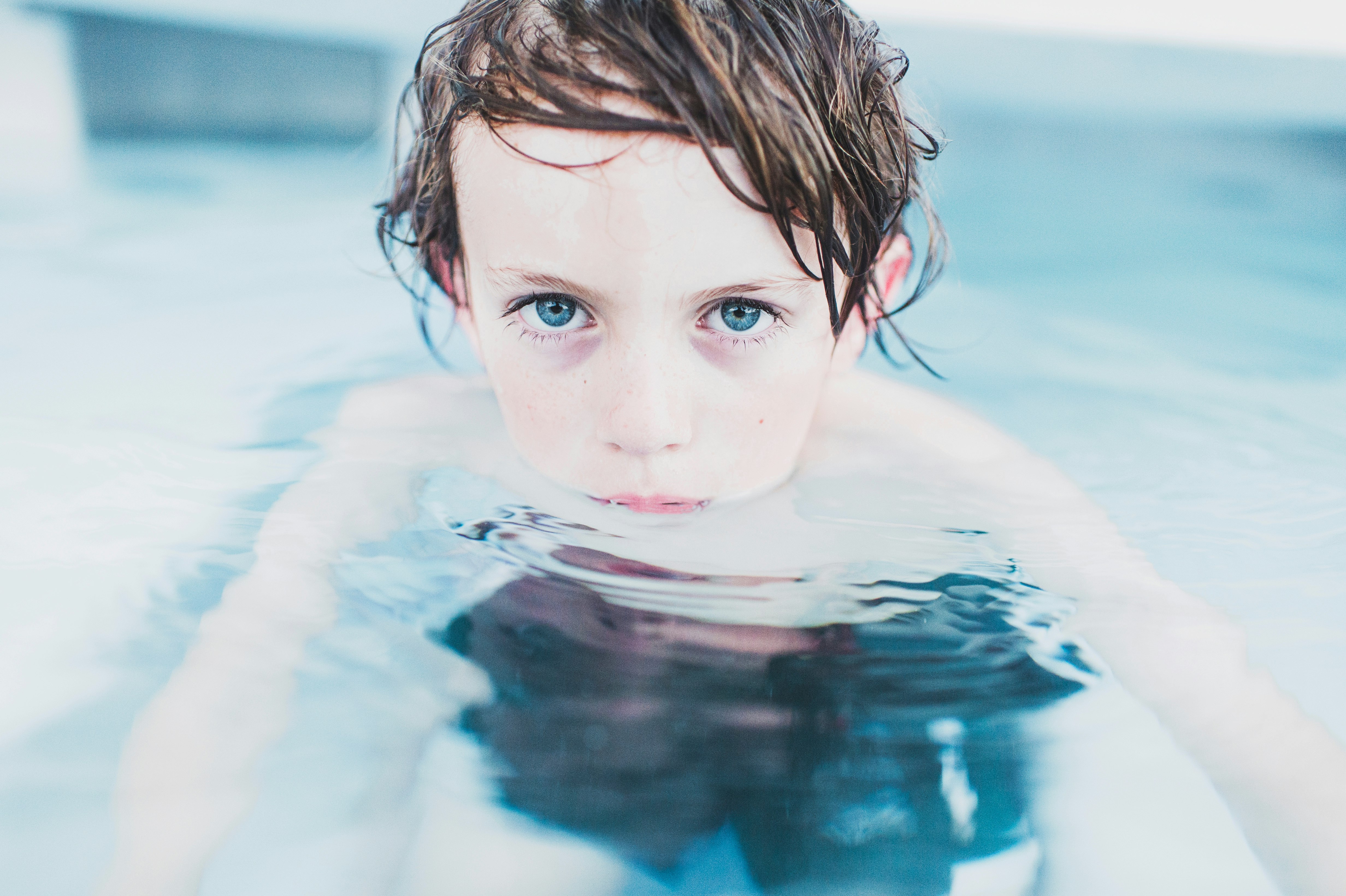 selective focus photography of boy floating on water